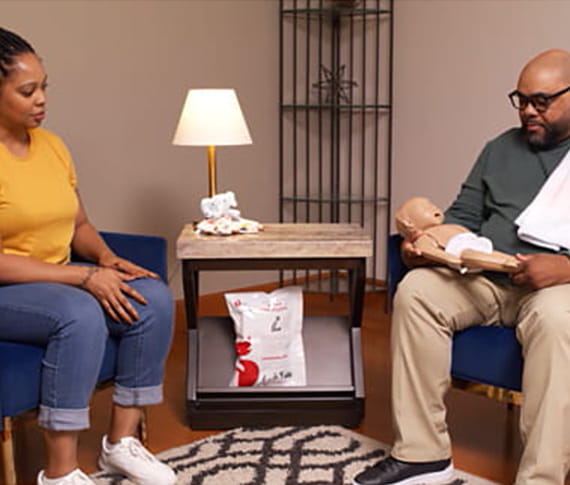 family practicing CPR infant