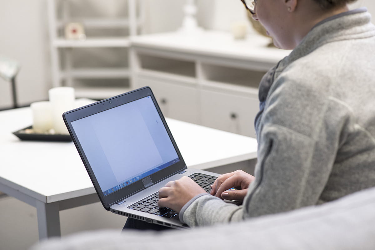 man with laptop sitting on sofa