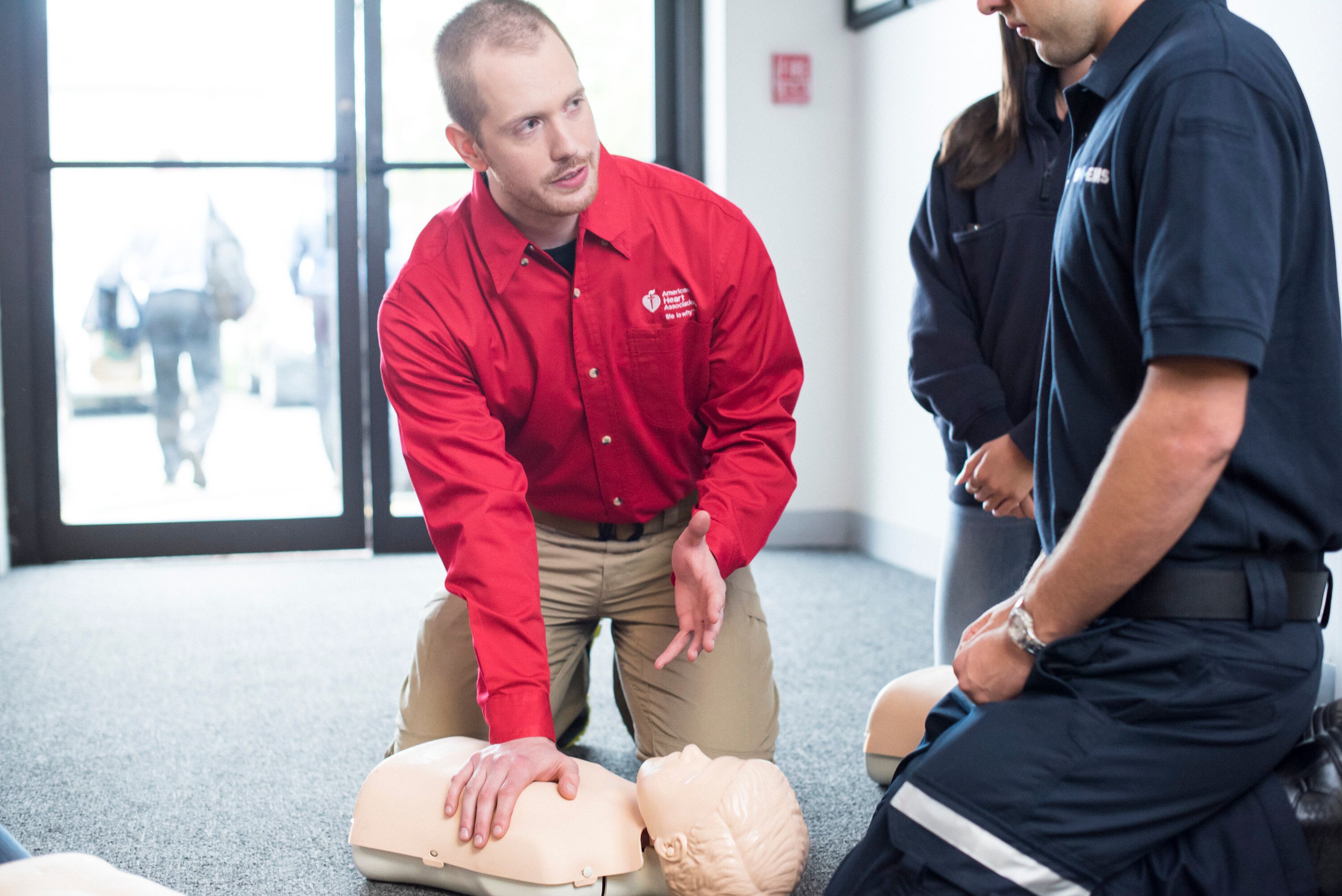 AHA instructor and paramedic CPR training on manikin 4Y3kqRY image