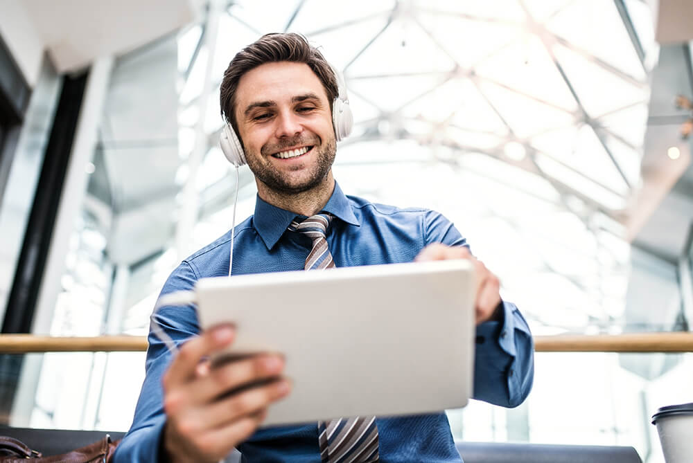 businessman_with_tablet_and_headphones_in_office